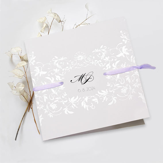Opening elegant wedding invitation with a pearl embossed ornament