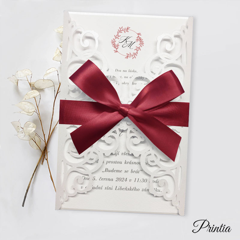 Wedding invitation with burgundy ribbon and initials of the engaged couple